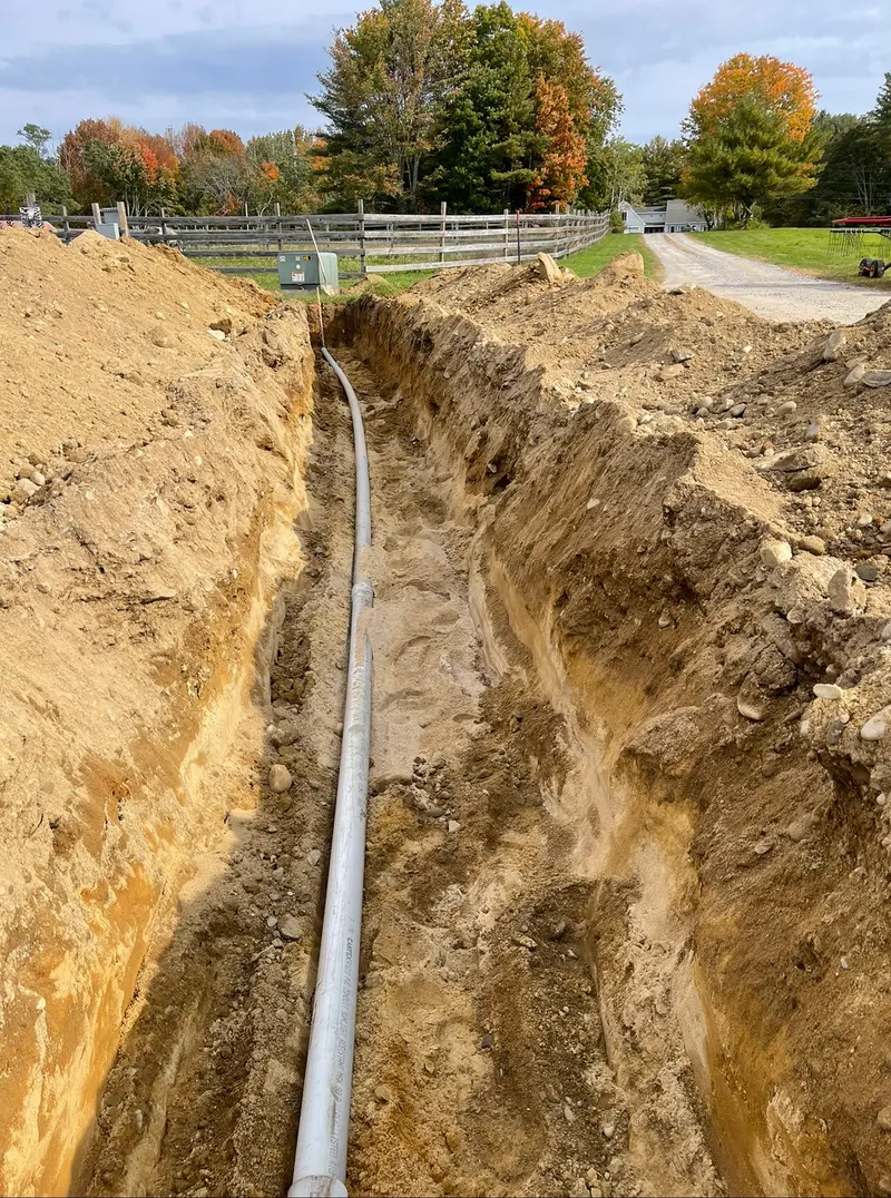 Deep drainage trench with pipe running across a property