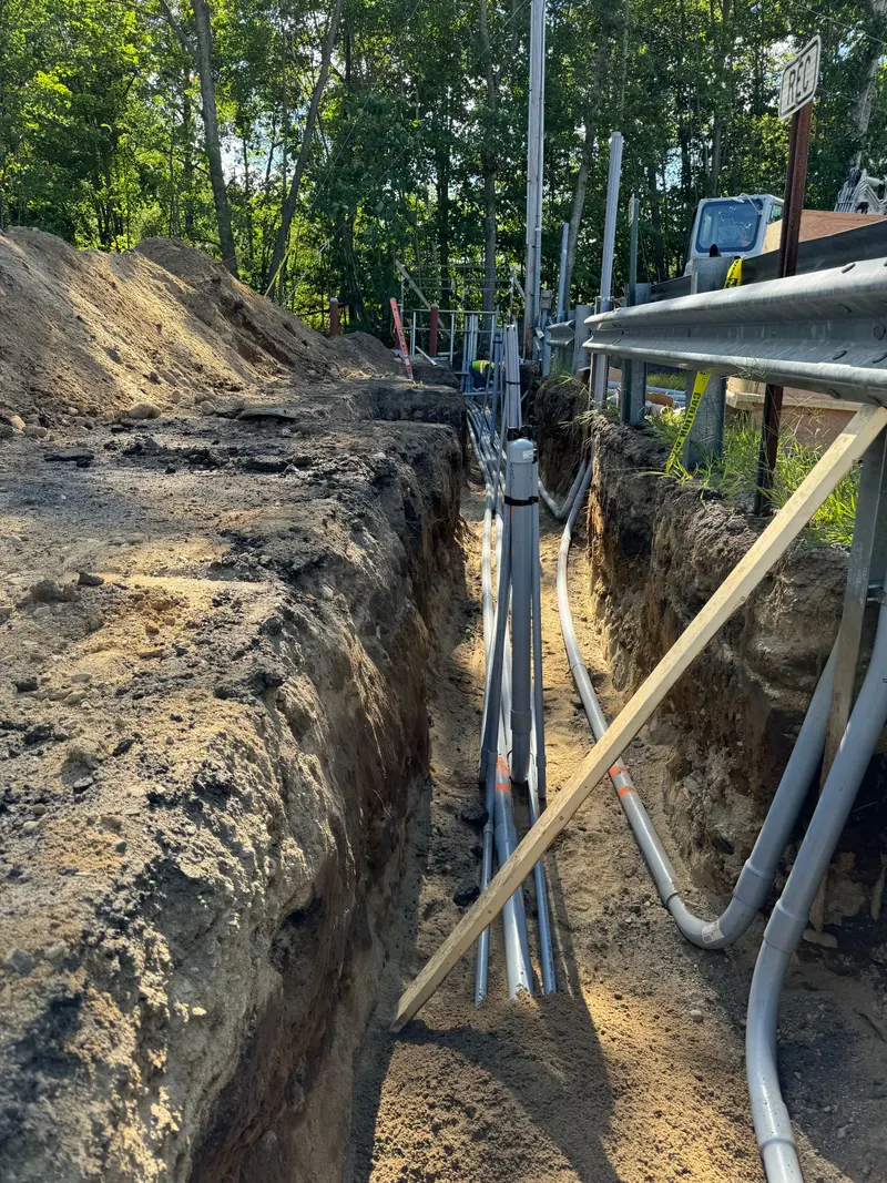 Open trench with drainage and utility piping run along a roadway